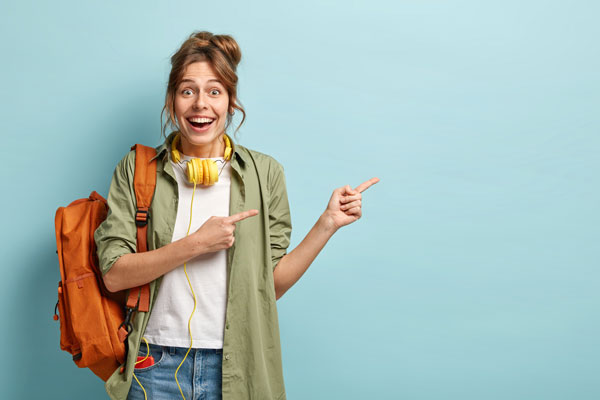 horizontal-shot-glad-caucasian-woman-points-aside-with-both-fore-fingers-advertises-something-aside